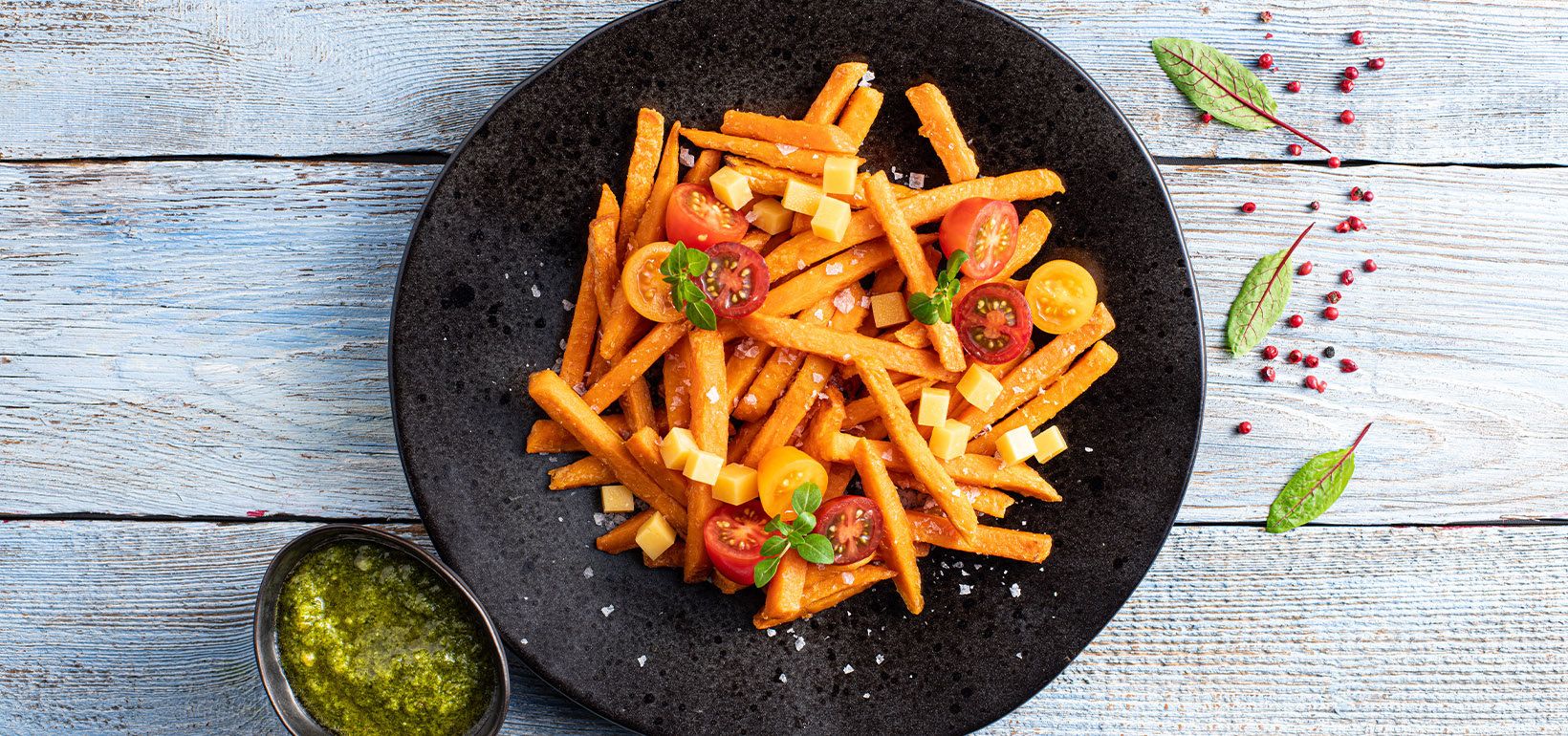Frytki z batatów z serem cheddar, kolorowymi pomidorkami i pesto